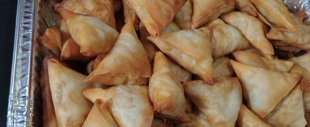 A tray of freshly fried samosas
